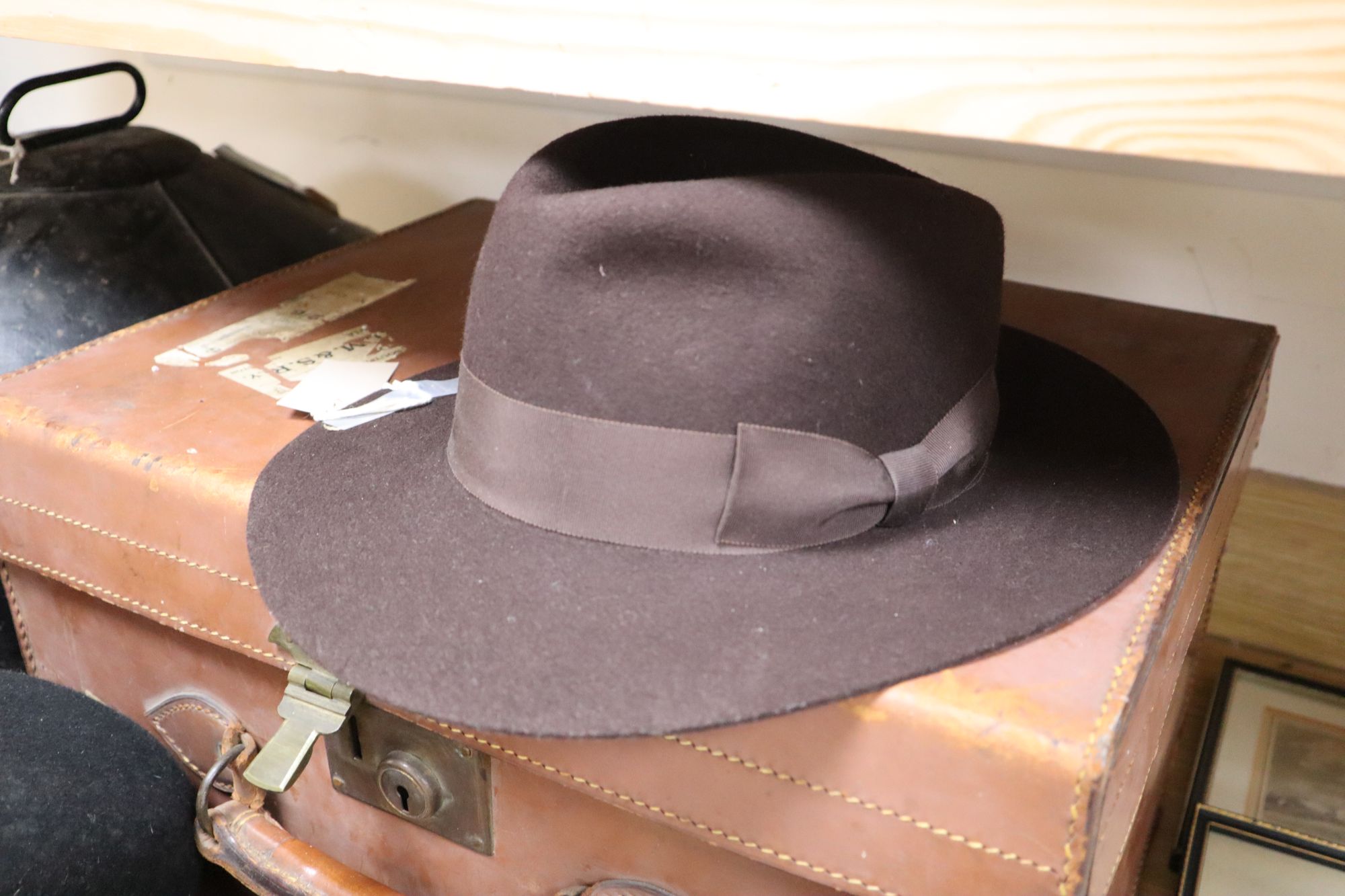 A solar pith helmet in japanned metal case, a military cap, a leather dressing case and seven other gentlemens hats, 9